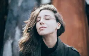 Eine Frau mit geschlossenen Augen genießt den Wind