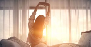 Eine Frau dehnt sich am Morgen