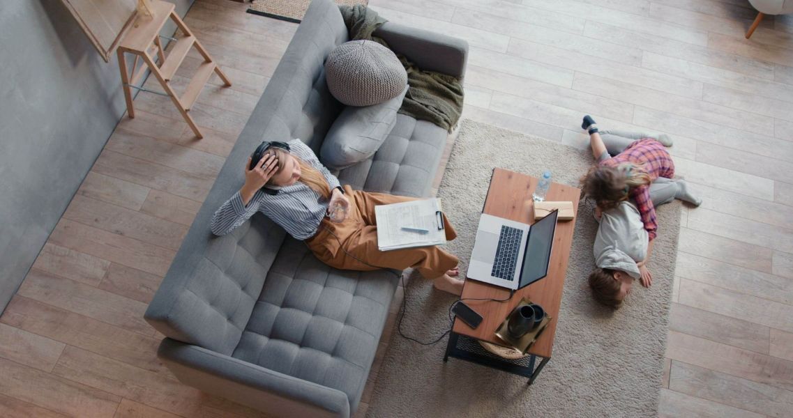 Frau sitzt erschöpft auf einer couch