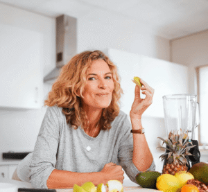 Blonde Frau isst ein Apfelstück