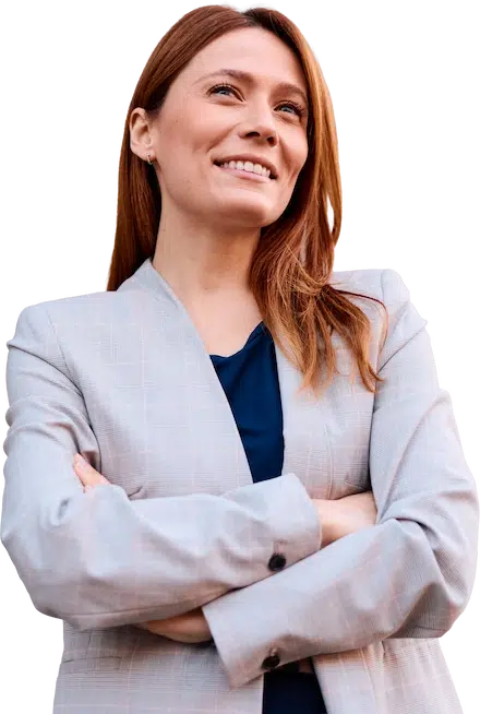 Eine Frau in einem hellgrauen Blazer blickt lächelnd in die Ferne